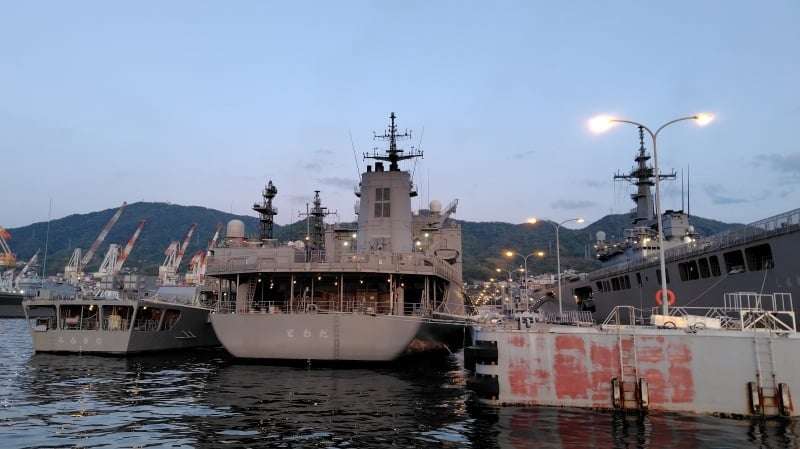 暮れゆく呉基地に停泊灯の灯る艦船